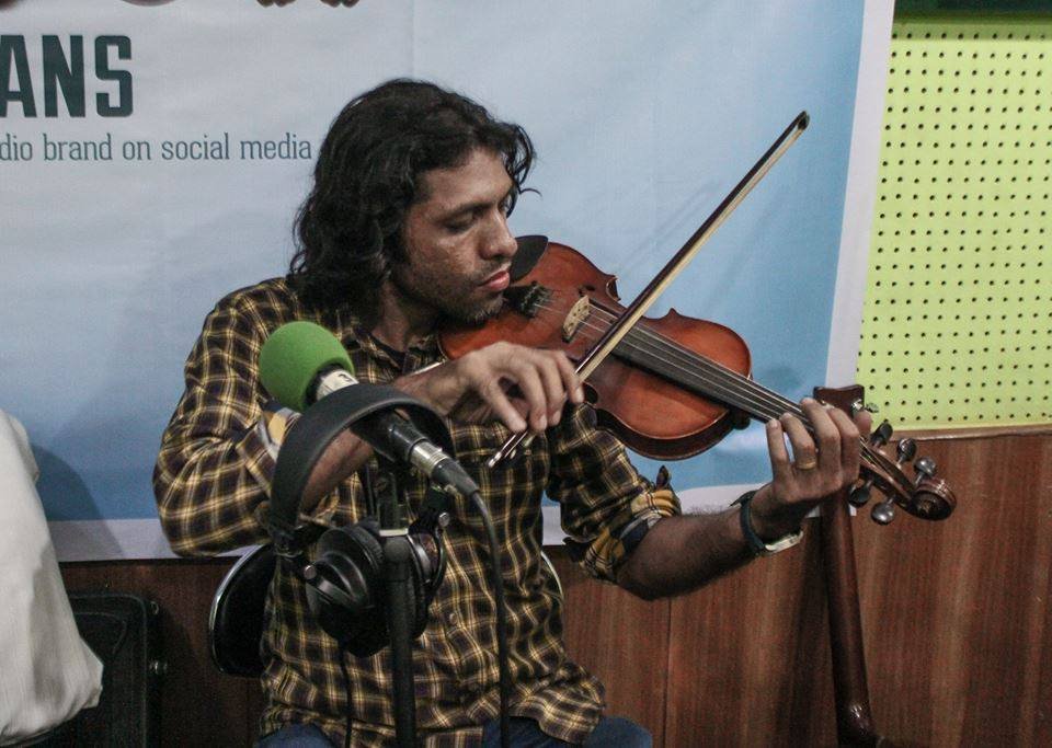 Shariful Islam playing violin during a radio session